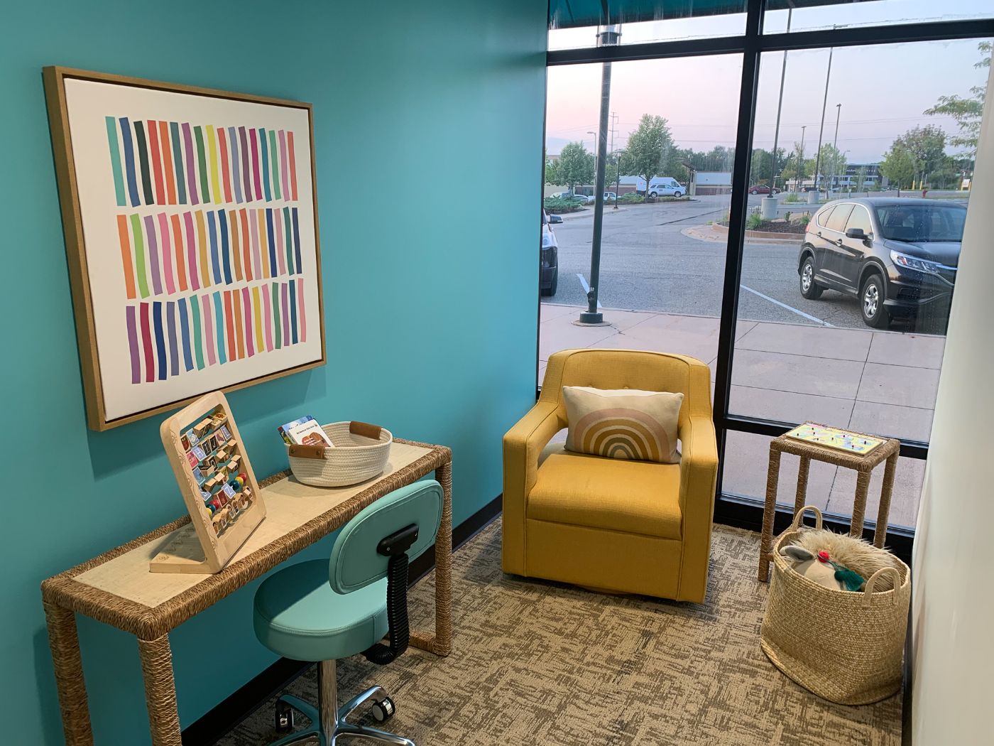 Bright consultation room at Maple Grove Pediatric Dentistry with teal walls and a sunny yellow armchair
